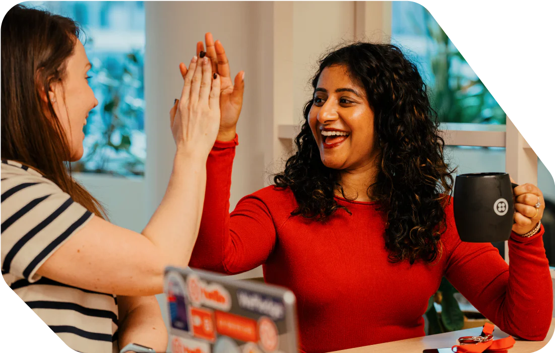 Colleagues Celebrate Success with High-Five at the Office Colleagues Celebrate Success with High-Five at the Office
