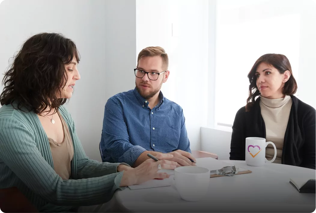 Three people sitting around a table